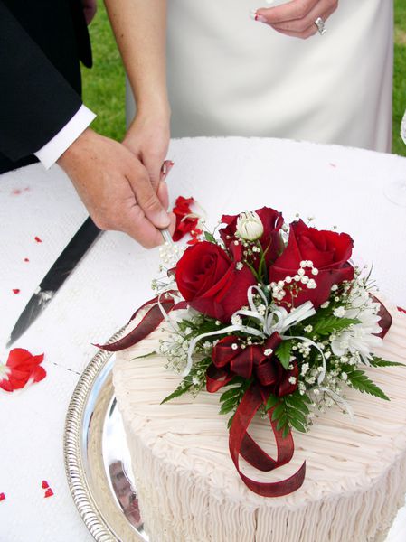 عروس و داماد در حال بریدن کیک عروسی