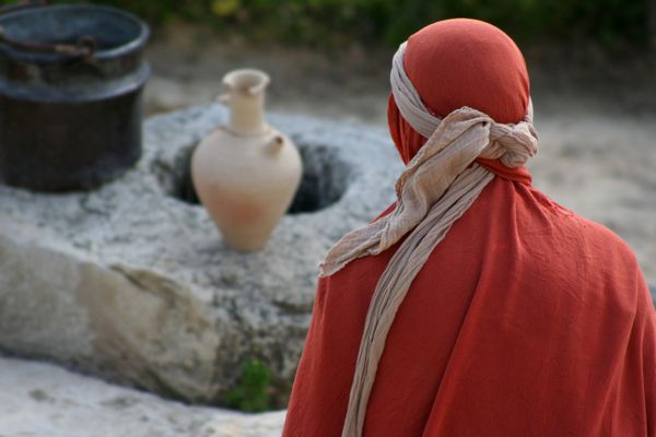 زنی که در پارچه پیچیده شده در مقابل چاه قرن اول نشسته است