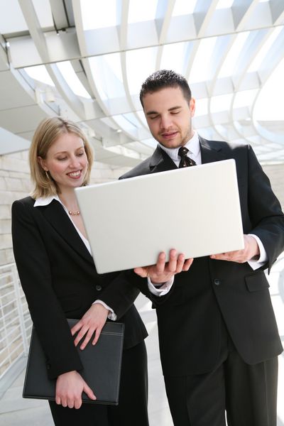 یک تیم تجاری زن و مرد جذاب با کامپیوتر در شرکت