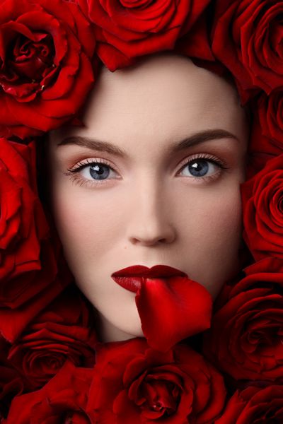 پرتره نزدیک دختر جوان زیبا با گل رز قرمز