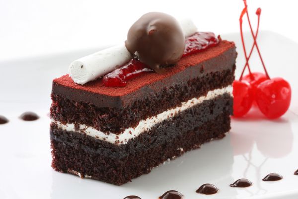 یک تکه کیک خوشمزه جنگل سیاه که با همه چیزهای خوب تزئین شده است