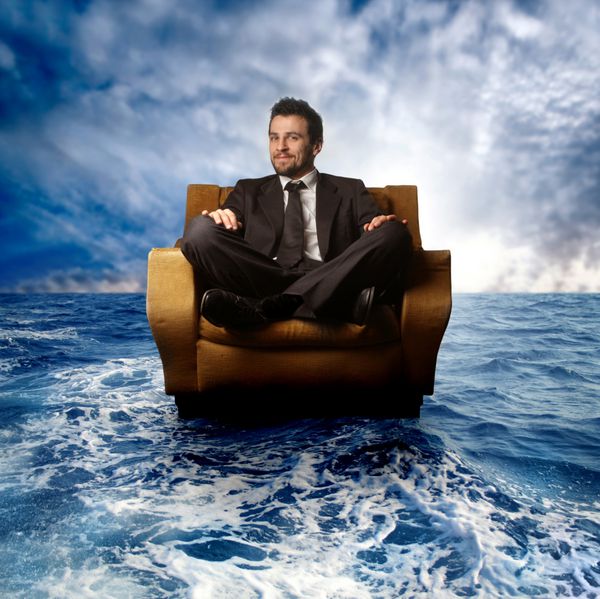 مرد تاجر روی بادبان صندلی راحتی در دریا