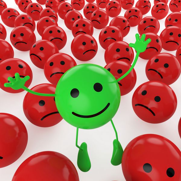 یک شکلک سبز شاد در حال پریدن در میان بسیاری از دیگران قرمز غمگین به عنوان مفهومی برای منحصر به فرد خوش بینانه شادی و تفاوت