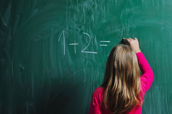 دختر مدرسه ای خوشحال در کلاس های ریاضی در حال یافتن راه حل و حل مسائل