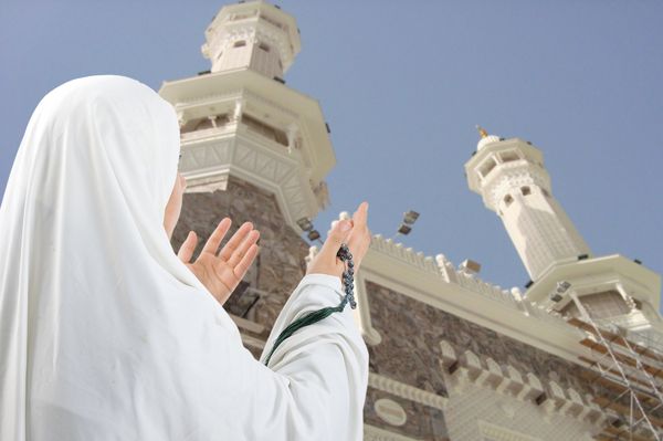 زن جوان زائر مسلمان با لباس سنتی سفید