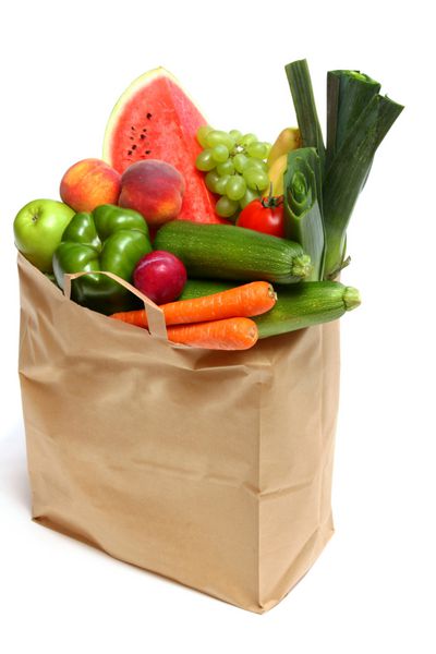 یک کیسه مواد غذایی پر از میوه ها و سبزیجات سالم روی سفید