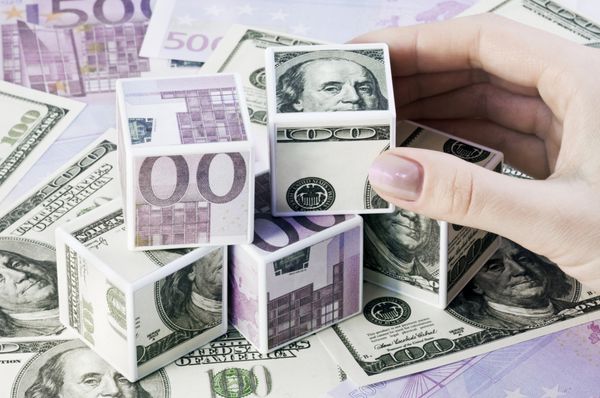 مکعب هایی از اسکناس های یورو و دلار که روی پس زمینه چیده شده اند