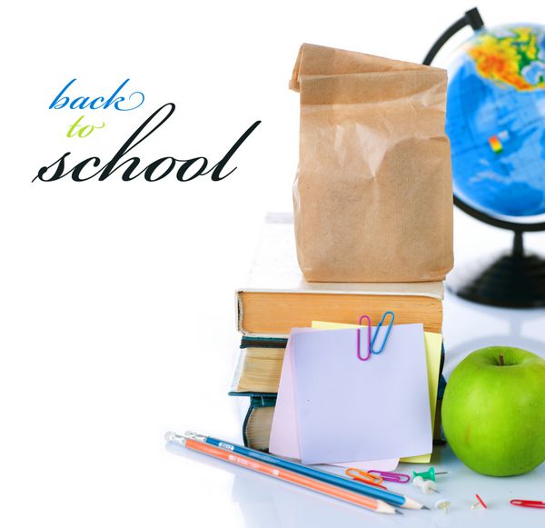 مفهوم بازگشت به مدرسه کتابهای مدرسه و سیب سبز جدا شده روی سفید