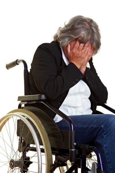 زن سالخورده ای که روی ویلچر نشسته و گریه می کند