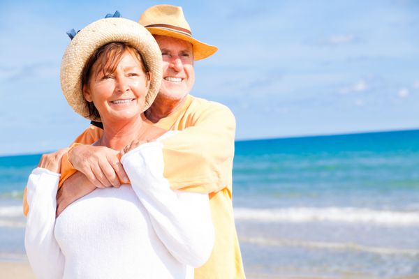 زن و شوهر سالخورده در تعطیلات تابستانی فعال و آرام در ساحل ایستاده اند