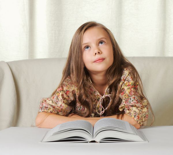دختر بچه هنگام خواندن کتاب در مورد چیزی خواب می بیند