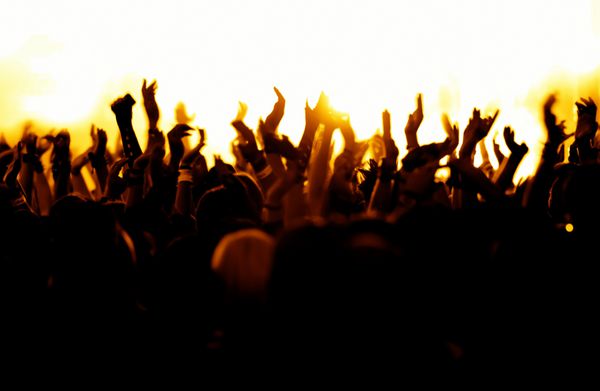 سیلوئت های جمعیت کنسرت در مقابل رنگ زرد روشن