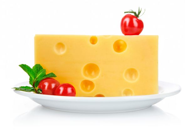 پنیر زرد در بشقاب با گوجه فرنگی و برگ سبز جدا شده در زمینه سفید
