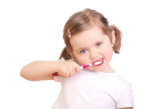دختر کوچکی که در حال مسواک زدن دندان هایش جدا شده روی پس زمینه سفید است
