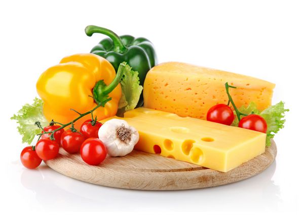 پنیر زرد با سبزیجات تازه جدا شده در زمینه سفید