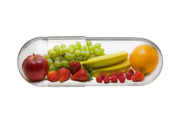 میوه های مختلف در کپسول - مفهوم رژیم غذایی سالم