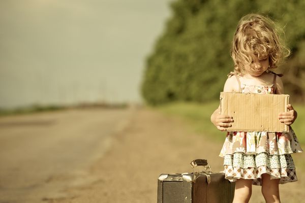 دختر تنها با چمدان ایستاده در اطراف جاده و نگه داشتن کاغذ با فضای کپی در دست