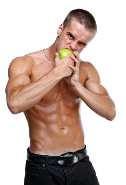 مرد ماهیچه ای که سیب سبز را می خورد