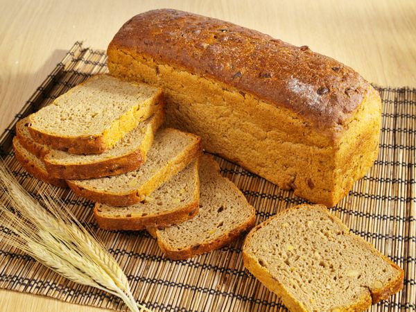 یک نان تازه پخته شده با دانه های سویا و گندم روی میز