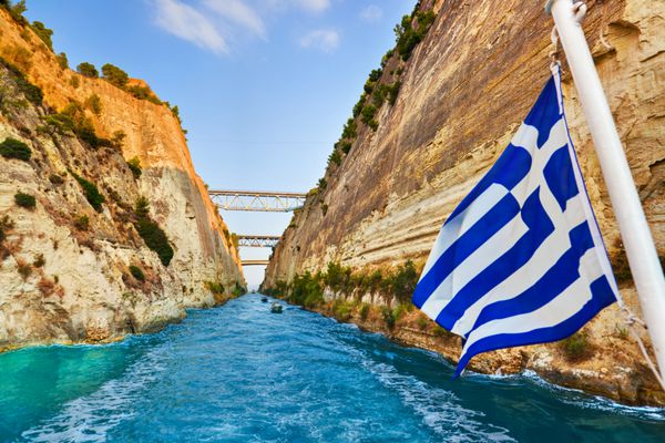 کانال Corinth در یونان و پرچم یونان در کشتی - پس زمینه سفر