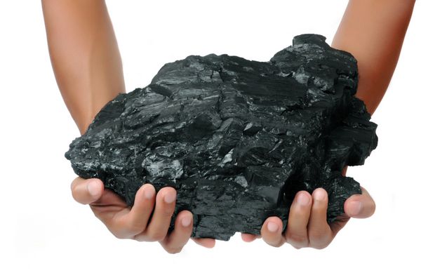 یک توده بزرگ زغال سنگ با دو دست جدا شده در زمینه سفید نگه داشته می شود