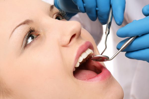 دندانپزشکی که دندان های بیمار را معاینه می کند نمای نزدیک تصویر