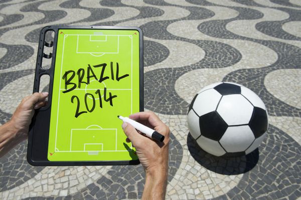 دست‌ها روی تخته تاکتیک‌های فوتبال می‌نویسند در آفتاب درخشان برزیل در پیاده‌روی کوپاکابانا ریودوژانیرو برزیل