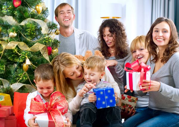 خانواده بزرگ شاد که هدایای کریسمس را در خانه نگه می دارند درخت کریسمس