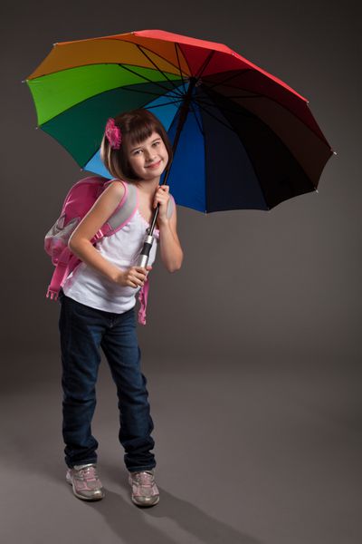 پرتره یک دختر کوچک زیبا که به مدرسه می رود شات استودیویی