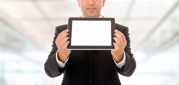 مرد تاجر رایانه رایانه لوحی را با صفحه نمایش لمسی با صفحه خالی در دست دارد و نشان می دهد