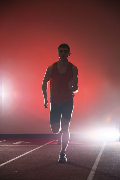 ورزشکار در حال دویدن در مسیر قرمز پس زمینه