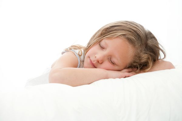 با کلید بالا پرتره نزدیک دختر کوچولوی ناز در خواب جدا شده در پس زمینه سفید