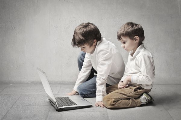 دو برادر کوچک که از لپ تاپ استفاده می کنند