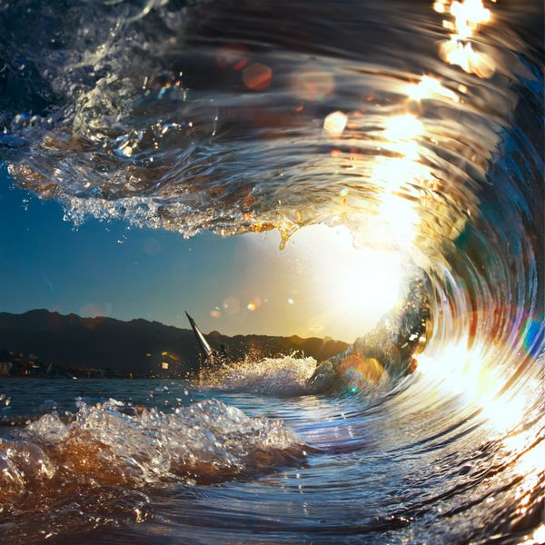 غروب خورشید موج فرفری شکستن دریا که در نور خورشید می درخشد