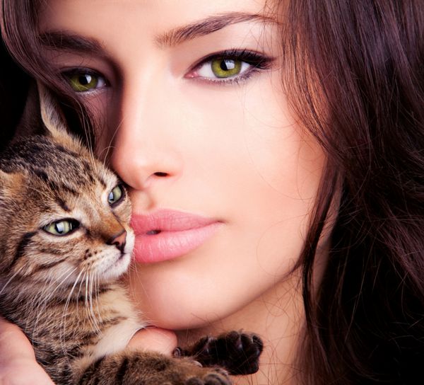 پرتره زن جوان زیبا که بچه گربه در دست دارد از نزدیک