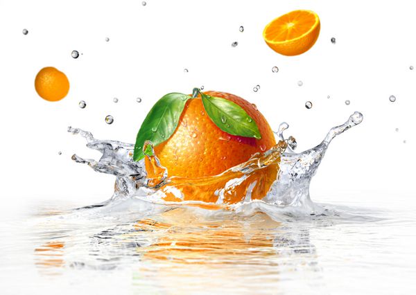 پاشیدن پرتقال در آب شفاف و دو نیمه دیگر در حال سقوط در زمینه سفید