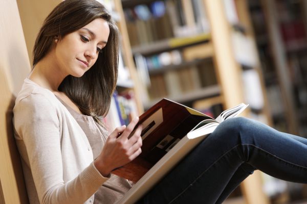 پرتره زن دانش آموز در حال خواندن کتاب در کتابخانه