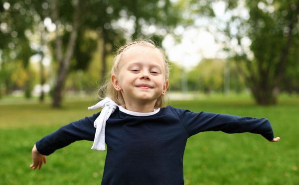 دختر کوچک شاد در پارک تابستانی سبز