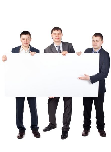 سه تاجر جوان تابلوی خالی بزرگی را که روی پس‌زمینه سفید جدا شده است در دست دارند