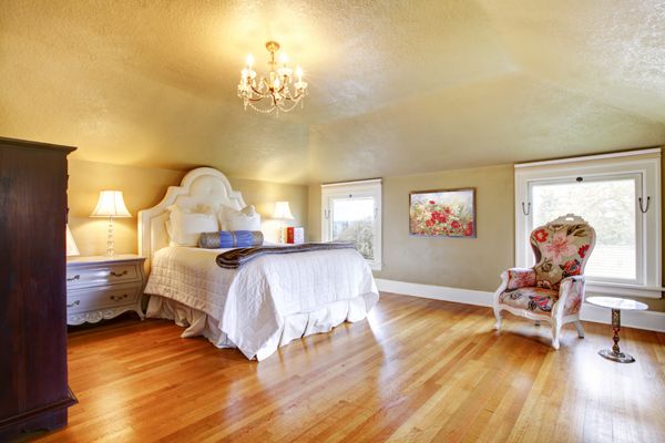 اتاق خواب لوکس طلایی با ملافه سفید و کف چوبی افرا