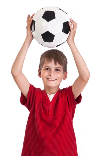 پسر ناز یک توپ فوتبال ساخته شده از چرم طبیعی جدا شده روی پس زمینه سفید را در دست دارد توپ فوتبال