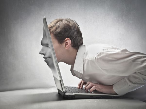 تاجر جوانی که سرش را از روی صفحه نمایش لپ تاپ می گذراند