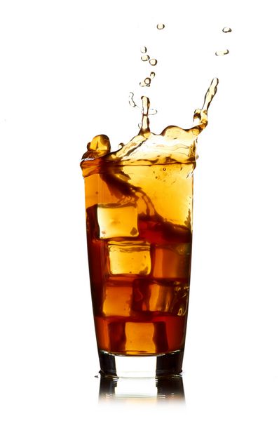 تکه یخ ریخته شده در لیوان کولا و پاشیدن کولا
