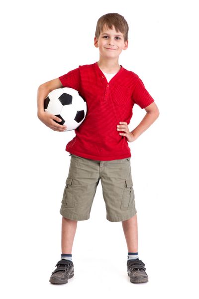 پسر ناز یک توپ فوتبال ساخته شده از چرم طبیعی جدا شده روی پس زمینه سفید را در دست دارد توپ فوتبال