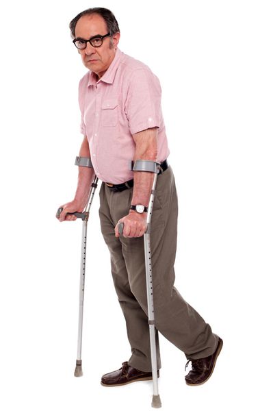 مرد سالخورده افسرده ایستاده با دو عصا جدا شده روی سفید