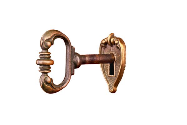 کلید قدیمی در سوراخ کلید جدا شده در پس زمینه سفید