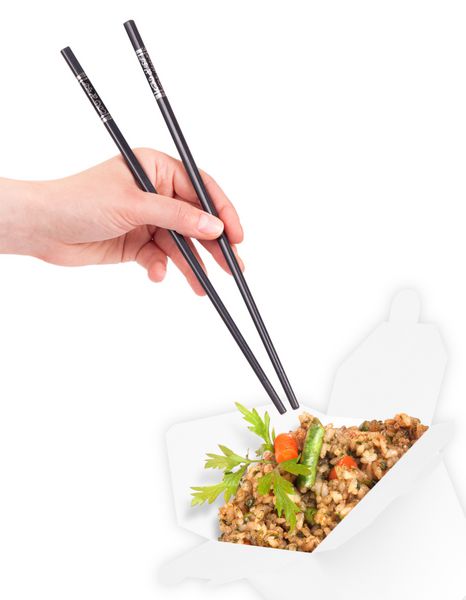 غذای چینی سالم در ظرفی با دست زنی که چاپستیک های جدا شده در دست دارد