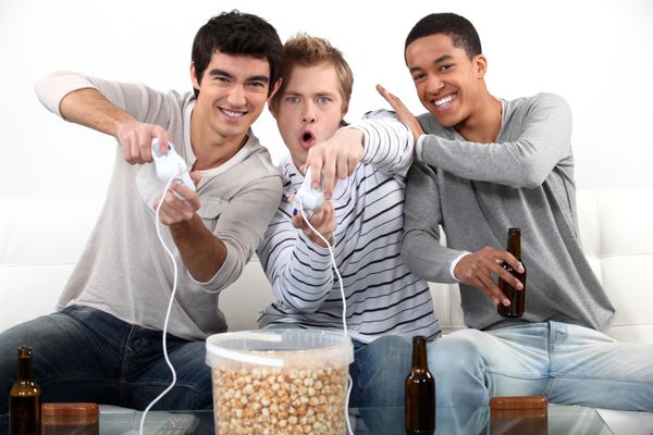 سه نوجوان مرد در حال بازی های ویدیویی