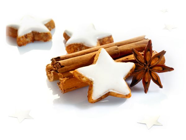 ادویه های کریسمس و طبیعت بی جان با کوکی های ستاره ای شکل خوشمزه چوب دارچین و بادیان ستاره ای در پس زمینه سفید