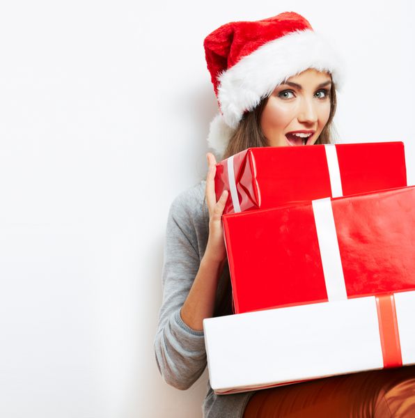 هدیه کریسمس نگهدارنده پرتره زن با کلاه بابانوئل کریسمس دختر شاد خندان در پس زمینه سفید